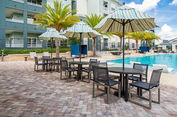 Outdoor Tables with Umbrellas on the Pool Sundeck